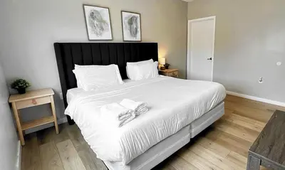 a bedroom with a large white bed with towels on it at Free Parking 15 Min to Hard Rock Stadium in Miami