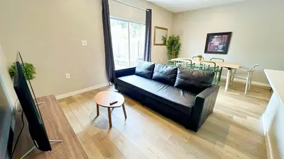 a living room with a black couch and a table at Free Parking 15 Min to Hard Rock Stadium in Miami