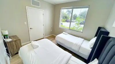 a small room with two beds and a window at Free Parking 15 Min to Hard Rock Stadium in Miami