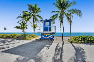 a blue life guard shack on the beach with palm trees at Desoto 2 Bedrooms in Hollywood