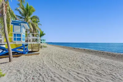 a blue and yellow house on a beach with palm trees at Desoto 2 Bedrooms in Hollywood