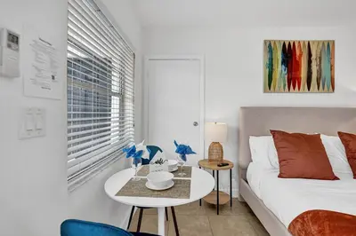 a white bedroom with a bed and a table and a window at Desoto 2 bedrooms first floor in Hollywood