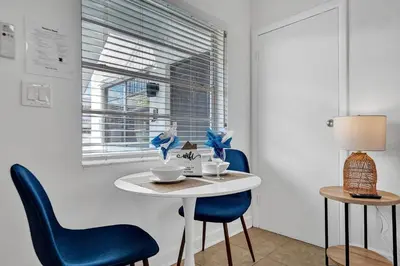 a white table with blue chairs and a window at Desoto 2 bedrooms first floor in Hollywood