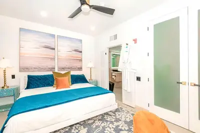 a bedroom with a bed and a ceiling fan at Boardwalk Steps from the Beach in Miami Beach