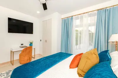 a bedroom with a bed and a window with blue curtains at Boardwalk Steps from the Beach in Miami Beach