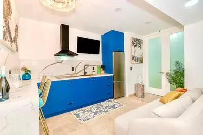 a living room with a couch and a blue cabinet at Boardwalk Steps from the Beach in Miami Beach