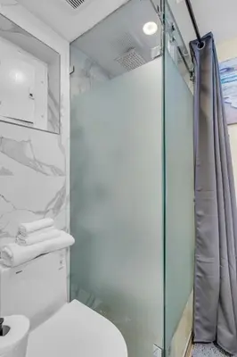 a bathroom with a glass shower and a toilet at Compact Miami Suite in Miami