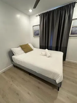 a bedroom with a bed with white sheets and a window at Prime Brickell Suites - One Free Parking With Self Check-in in Miami