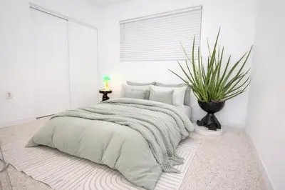 a bedroom with a bed with a blanket and a plant at Tropical backyard with pool 10 min from Miami Beach! in Miami