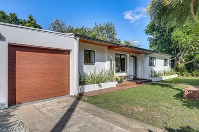 a house with a wooden garage at Tropical backyard with pool 10 min from Miami Beach! in Miami