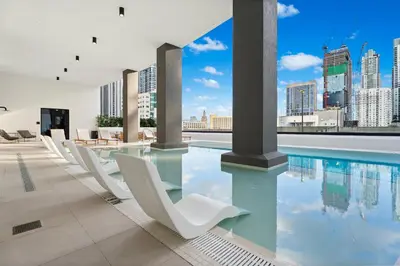 a pool with chairs and a view of the city at Prime Downtown Location - Amazing Amenities & Top Location in Miami