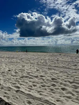 a beach with people walking on the sand and the ocean at Casablanca Beachfront with full kitchen in Miami Beach