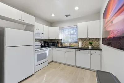 a kitchen with white cabinets and a white refrigerator at Prime Location Miami House W Free Parking in Miami