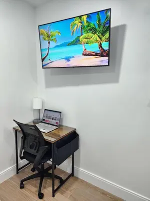 a desk with a laptop and a computer on a wall at Private & Quiet Retreat Near Hard Rock Stadium and Guitar Hotel in Pembroke Pines