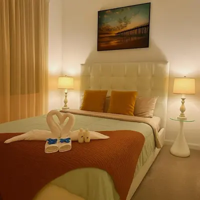 a bedroom with a bed with two towels and two shoes at NEW House, Near Beaches, and MIA, Sleeps 8! in Westview