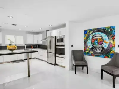 a kitchen with a table and two chairs and a painting at Villa Zenora in Miami