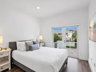 a white bedroom with a large bed and a window at Villa Zenora in Miami