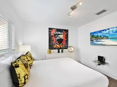 a white bedroom with a bed and a painting on the wall at Villa Zenora in Miami