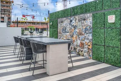 a bar on a rooftop with a green wall at Brickell Border 3BR by Untitled Stay in Miami