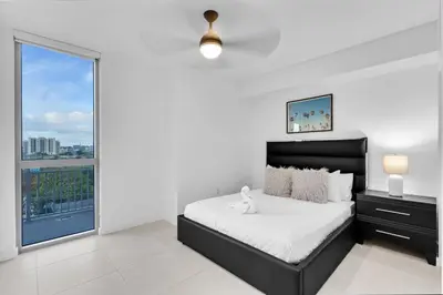 a bedroom with a bed and a large window at Brickell Border 3BR by Untitled Stay in Miami