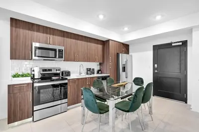 a kitchen with a glass table and green chairs at Brickell Border 3BR by Untitled Stay in Miami