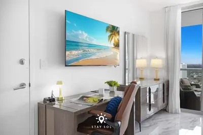 a dining room with a desk and a view of the beach at Spacious 2BR apt - Amazing Balcony View in Hallandale Beach