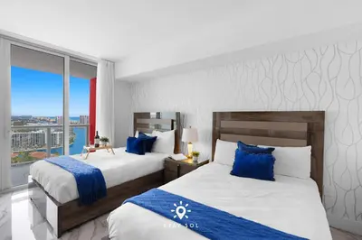 two beds in a hotel room with blue pillows at Spacious 2BR apt - Amazing Balcony View in Hallandale Beach
