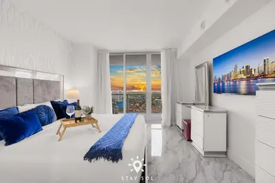 a bedroom with a large bed and a tv at One Bedroom - Amazing Balcony in Hallandale Beach