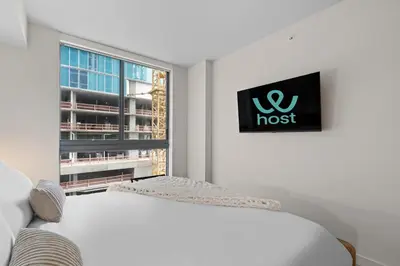 a white room with a bed and a window at Skyline Views - Steps from Bayfront Park in Miami