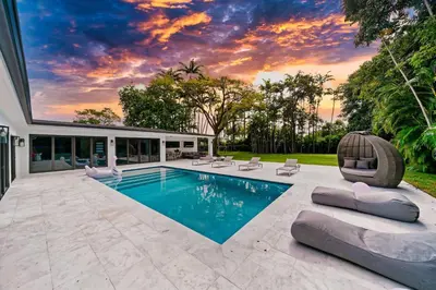 a swimming pool in a backyard with a sunset at Two Neighboring Villas in The Heart of Miami in Miami