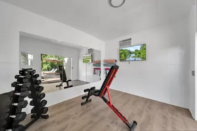 a room with a gym with a treadmill and weights at Two Neighboring Villas in The Heart of Miami in Miami