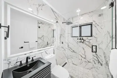 a bathroom with a sink and a mirror at Two Neighboring Villas in The Heart of Miami in Miami