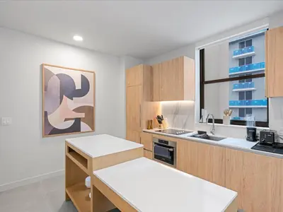 a kitchen with white counters and wooden cabinets at Spectacular Cityviews - Steps from Bayfront Park in Miami