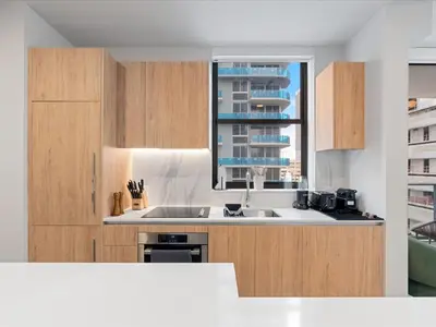 a kitchen with wooden cabinets and a sink and a window at Spectacular Cityviews - Steps from Bayfront Park in Miami