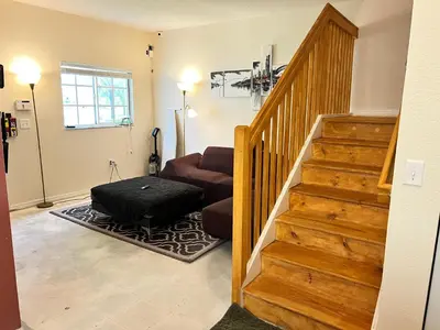 a living room with a staircase and a couch at Queen with Private Dedicated Spa Bath in Miami