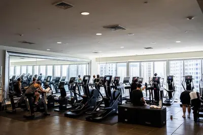 a group of people exercising in a gym at Brickell 35th Floor Residence with Saltwater Pool 5-Star Amenities in Miami