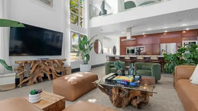 a living room with a large tv and a table at Jungle Penthouse Private Pool in South Beach in Miami Beach