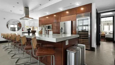 a kitchen with a bar with stools and a counter at Jungle Penthouse Private Pool in South Beach in Miami Beach
