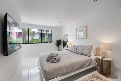 a white bedroom with a bed and two windows at 2BR near Bal Harbour beautiful in Miami Beach