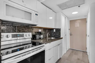 a kitchen with a stove and a microwave at Beachfront Resort Studio with 2 Queen beds, Balcony & Pool in Sunny Isles Beach