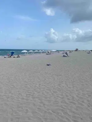 a sandy beach with umbrellas and the ocean at Waterviews studio at the beach #mybeachspotmiami in Miami Beach