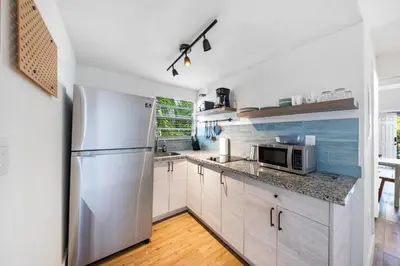 a kitchen with white cabinets and a stainless steel refrigerator at Retro Miami RareFREE Parking 1 Min to Beach in Miami Beach