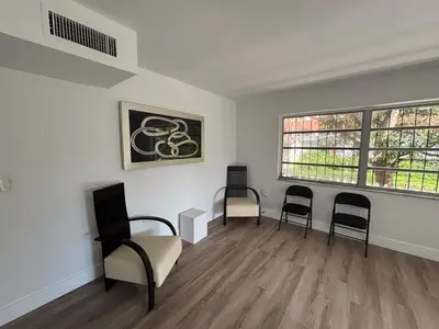 an empty room with two chairs and a window at CG Miami House in Miami