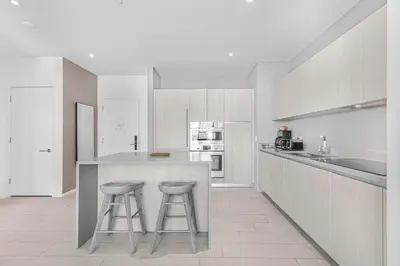 a white kitchen with two stools at a counter at Hyde Dream Penthouse in Hollywood