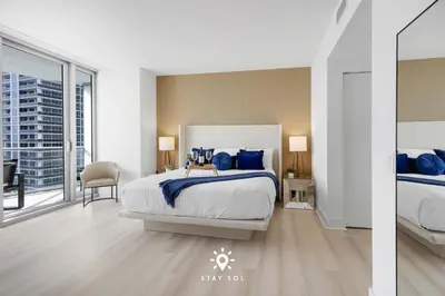 a bedroom with a large bed with blue pillows at Oceanline 3BR Corner Balcony & Calm Seas in Hollywood