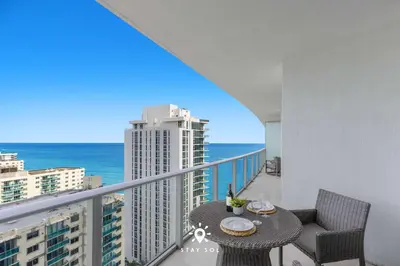 a balcony with a table and chairs and the ocean at Insane Ocean View Balcony - Beachfront Resort & Pool in Hollywood
