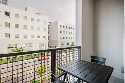 a table and chairs on a balcony with a building at Blueground Coral Gables pool wd nr Vizcaya MIA-125 in Miami