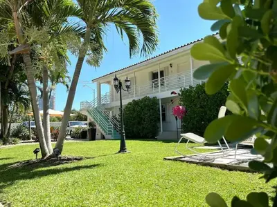 a house with a yard with palm trees and a chair at B08 10 MIN FROM MIAMI BEACH, Studio, Miami Design District & Wynwood in Miami
