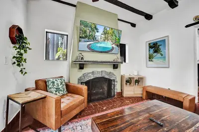 a living room with a fireplace and a table at Spanish 5 Bedroom Pool House Minutes to the Beach in Hollywood