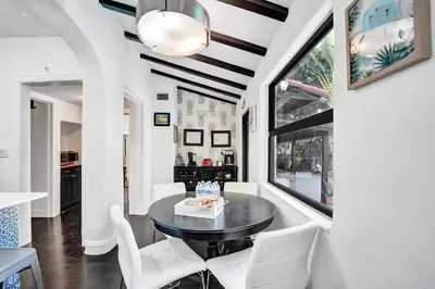 a dining room with a black table and white chairs at Spanish 5 Bedroom Pool House Minutes to the Beach in Hollywood